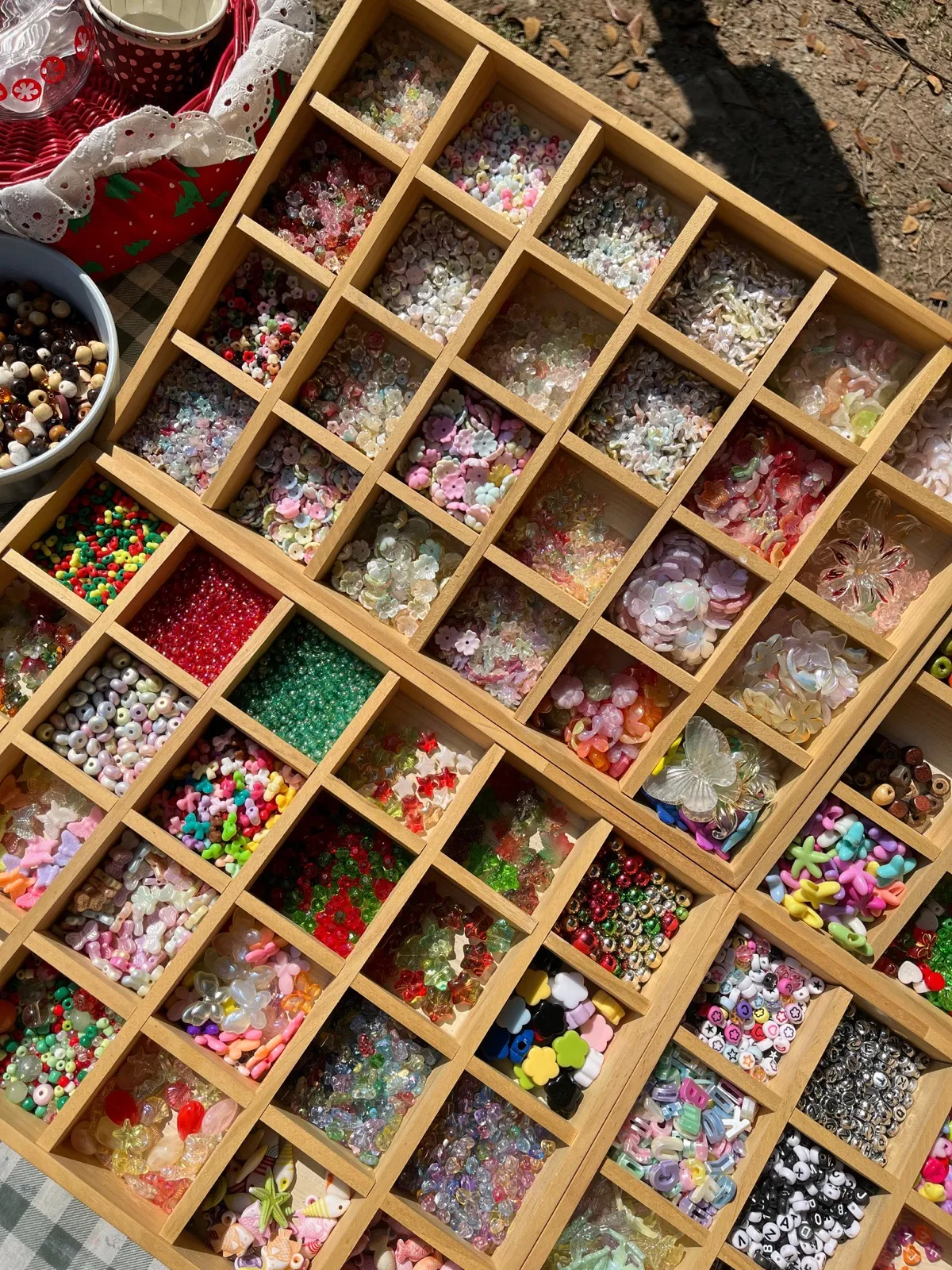Wooden organizer with assorted colorful beads in compartments.