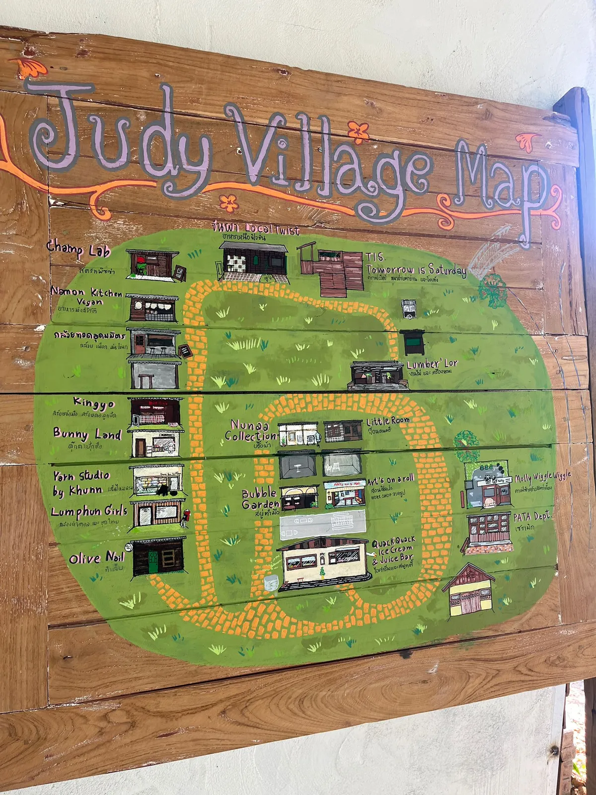 Hand-painted Judy Village map on wood with colorful illustrations.