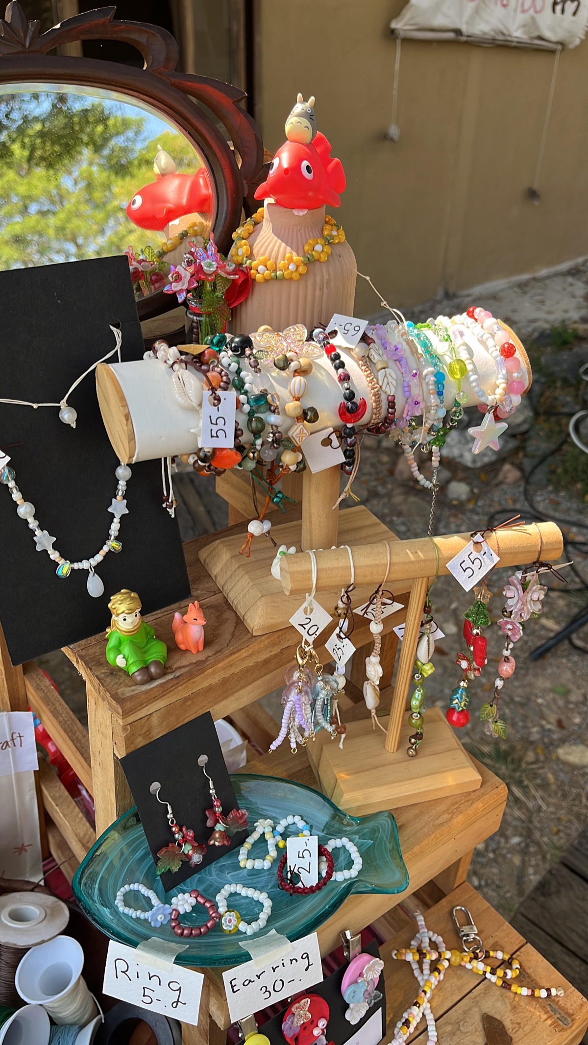 Handmade jewelry display featuring colorful necklaces, earrings, and rings