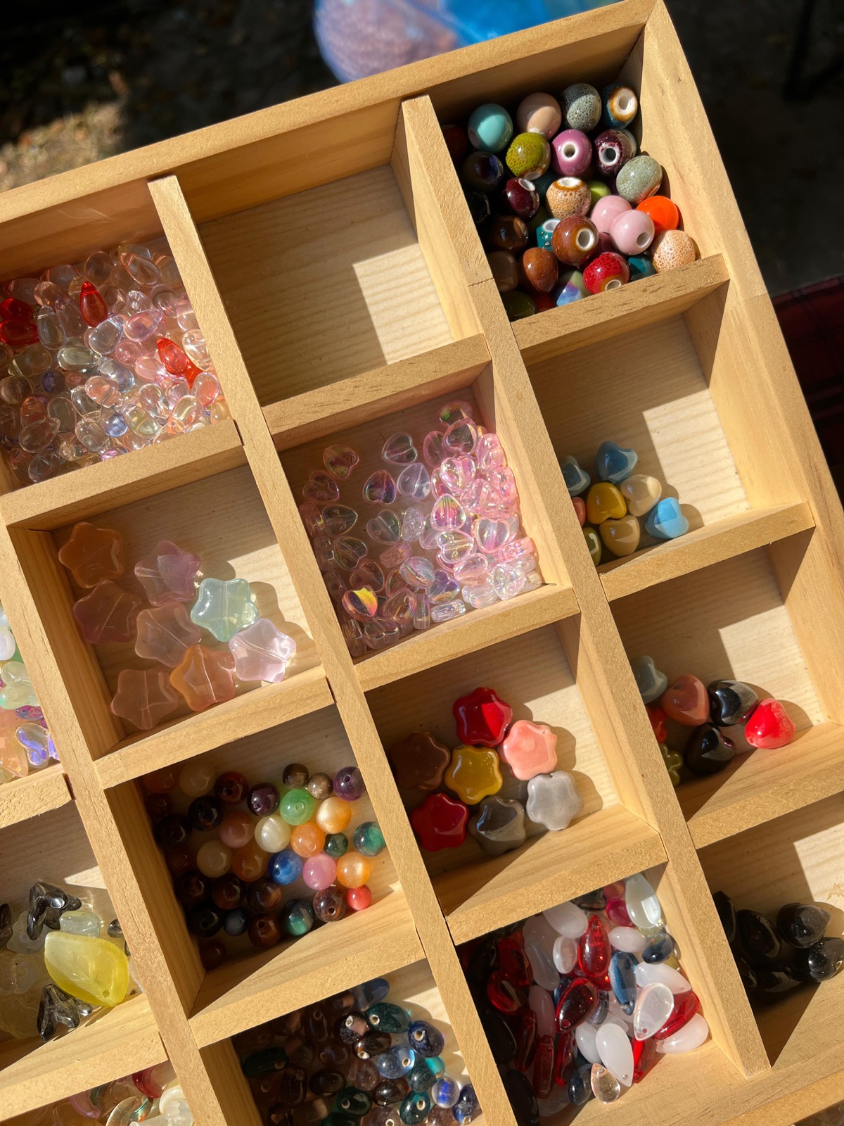 Colorful beads organized in a wooden tray at a workshop